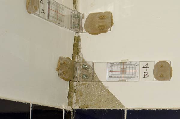 lesioni sui muri - Due fessurimetri angolari in opera su un mero di un'abitazione per la lettura degli spostamenti